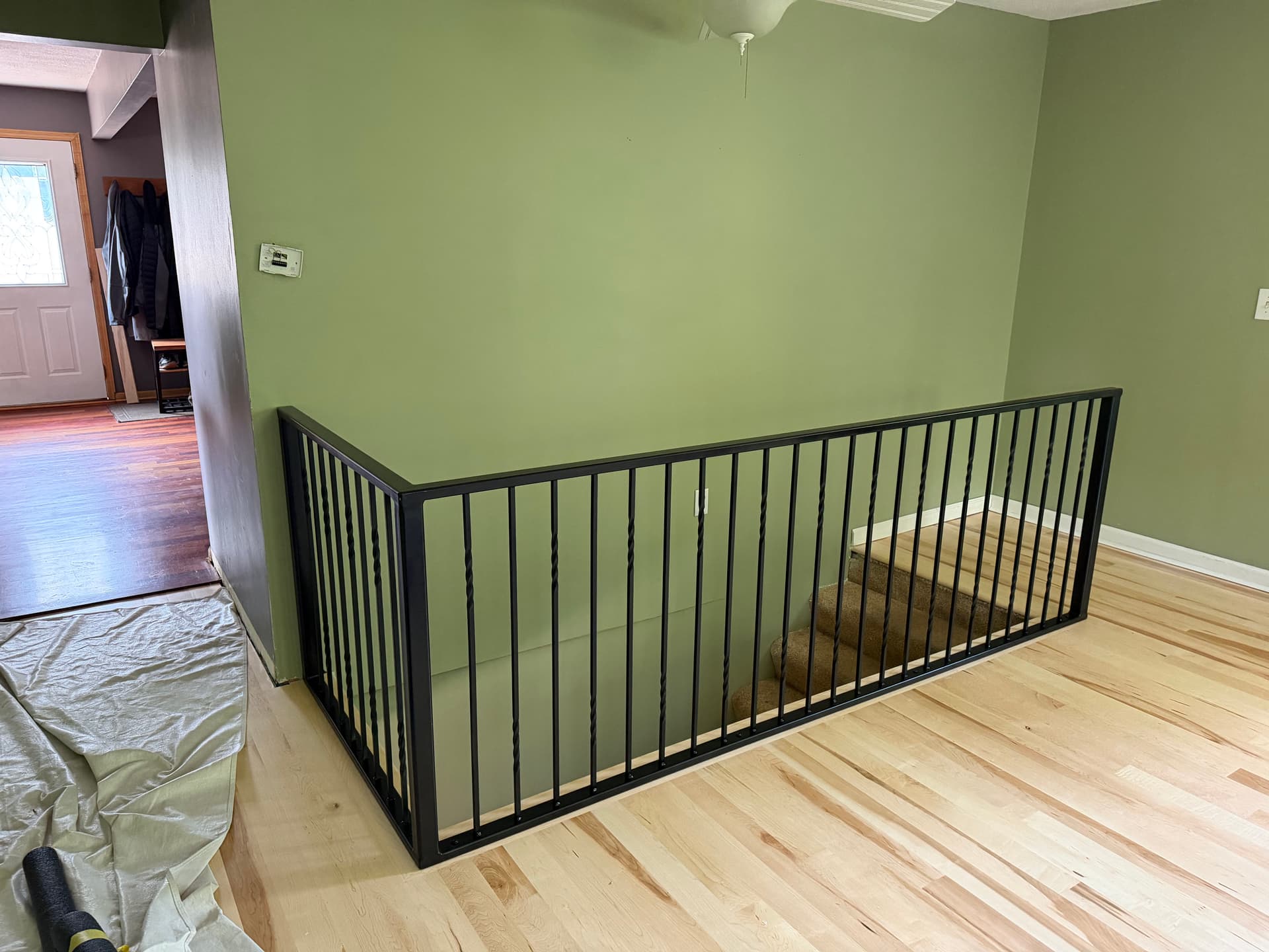 Custom Interior Metal Railing Wraps a Staircase Opening Clean image