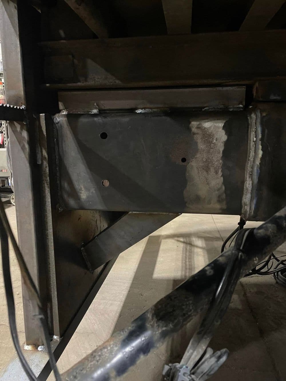 Close-up of industrial metal frame with welded joints and mounting holes for structural support.
