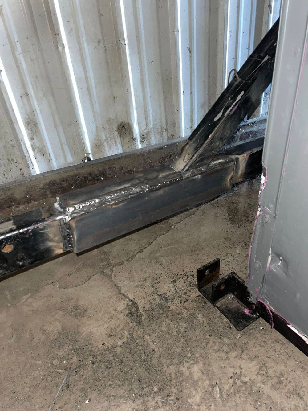 Metal welded structure showing detailed seam and support in industrial setting.